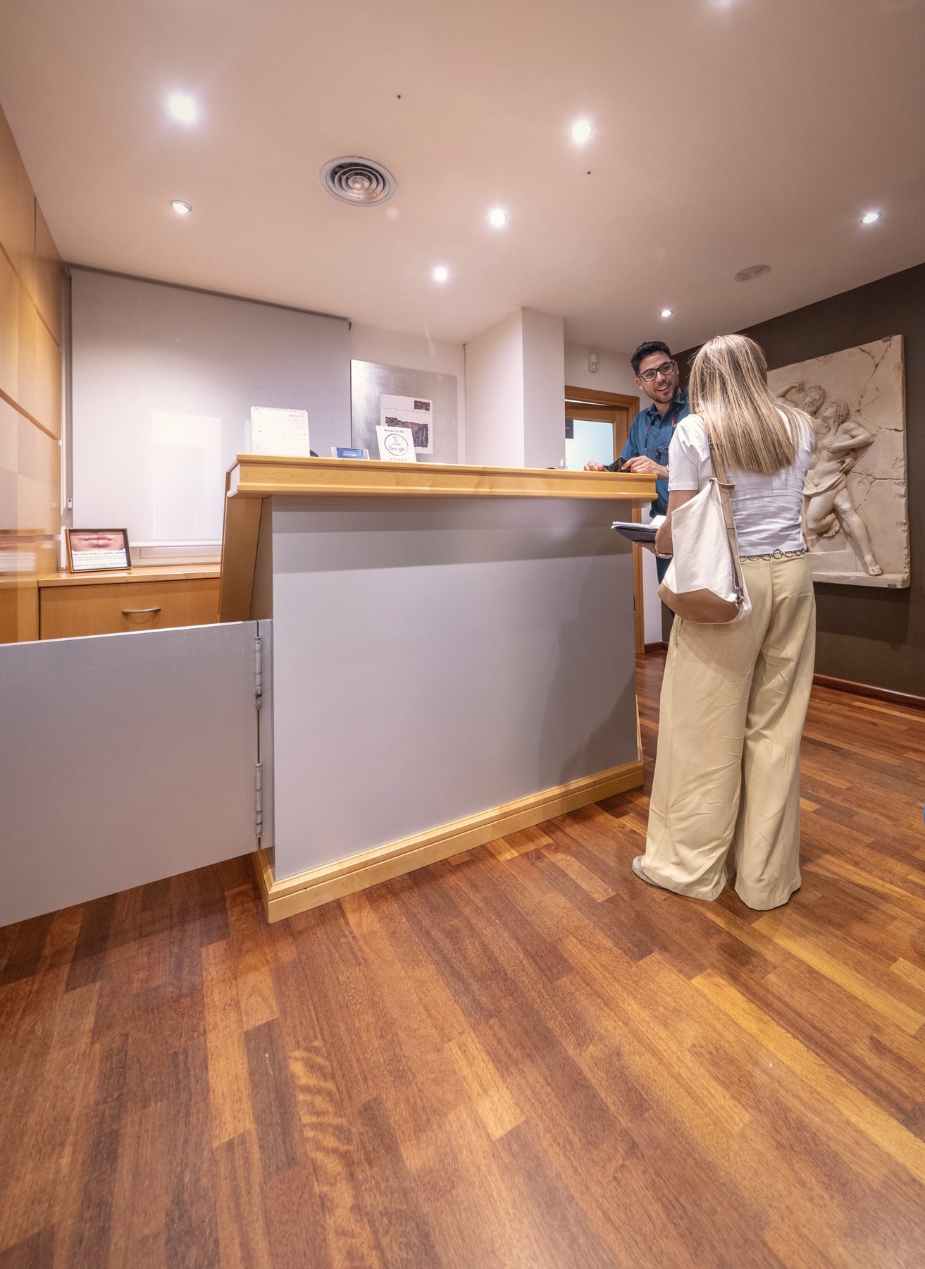 Recepción de la clínica con suelo de madera cálida